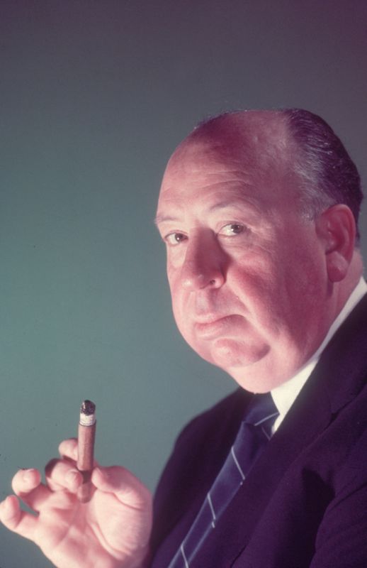 Alfred Hitchcock hält eine Zigarre