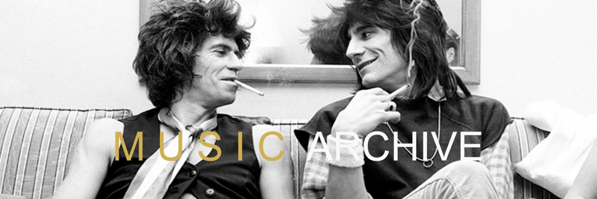Rolling Stones band members Keith Richards and Ronnie Wood enjoy a smoke and a chat on a sofa in New York 1978.  They were promoting their side band New Barbarians. Photo by Michael Putland limited edition estate prints available from Galerie Prints.