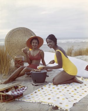Young Women Eating Hot Dogs On The Beach